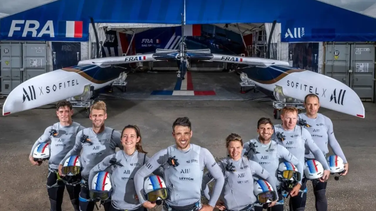 L'équipe française du SailGP France pose fièrement devant son catamaran, prête à conquérir les océans.