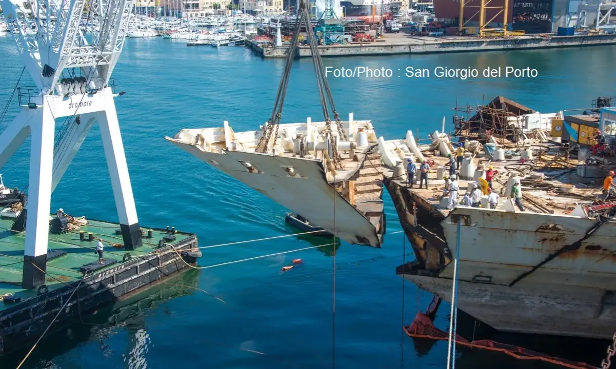 Démantèlement du Costa Concordia : une section du navire est soulevée par une grue dans un port.