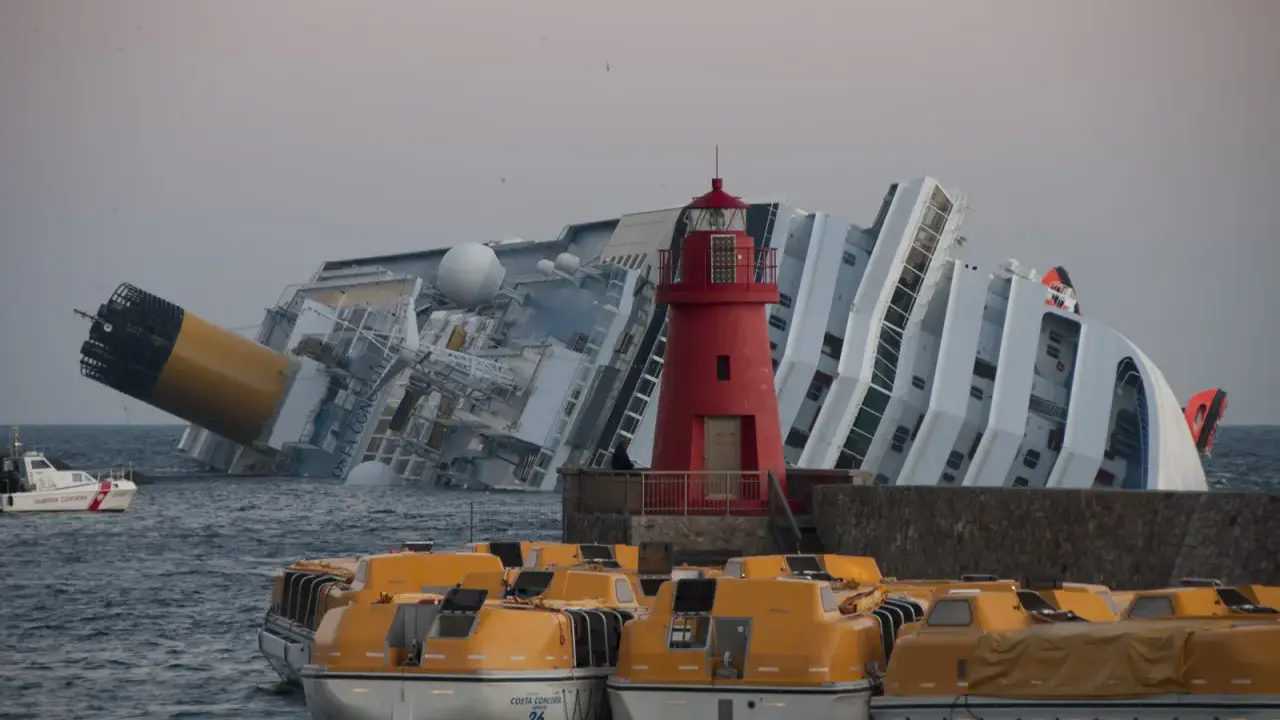 Épaves du Costa Concordia, symbole tragique de la mer. Des canots de sauvetage orange attendent, rappelant le naufrage et ses morts.