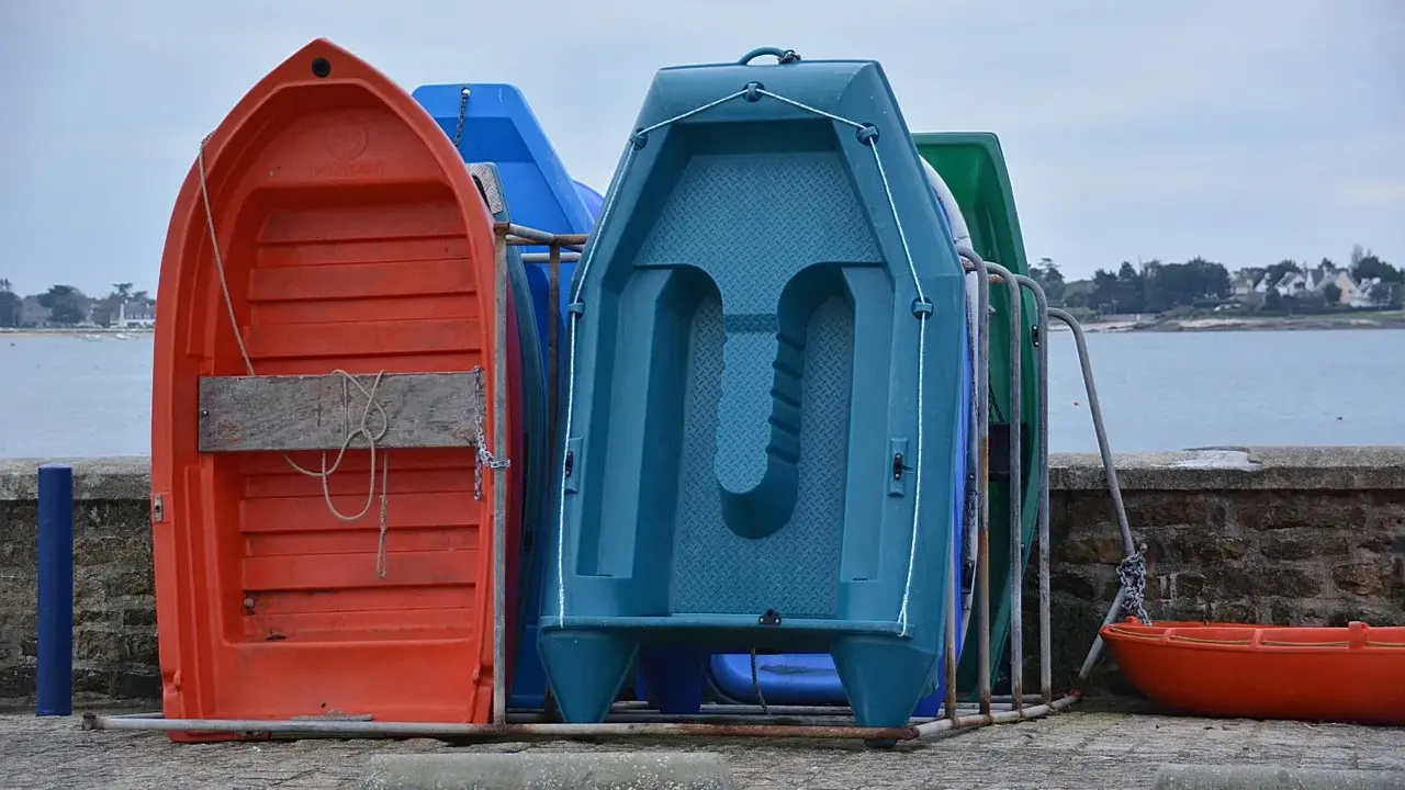 Plusieurs petites barques colorées sont rangées sur le quai, prêtes à être utilisées pour rejoindre son bateau.