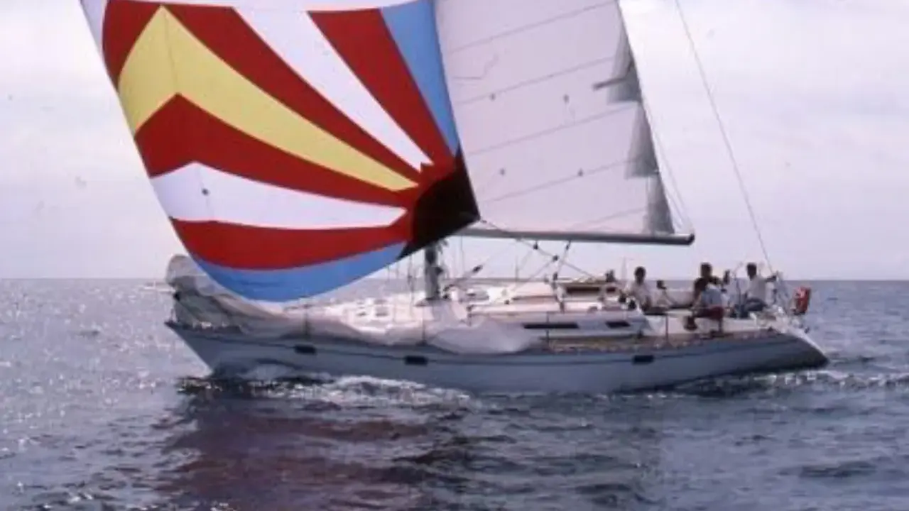 Un voilier avec une voile colorée, rappelant une légende du soleil, navigue sur une mer agitée. 41 avis sur cette aventure.