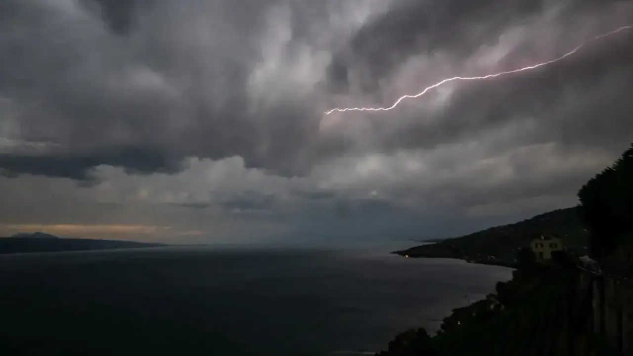 Éclair zébrant le ciel sombre au-dessus du lac Léman, annonçant une violente tempête.