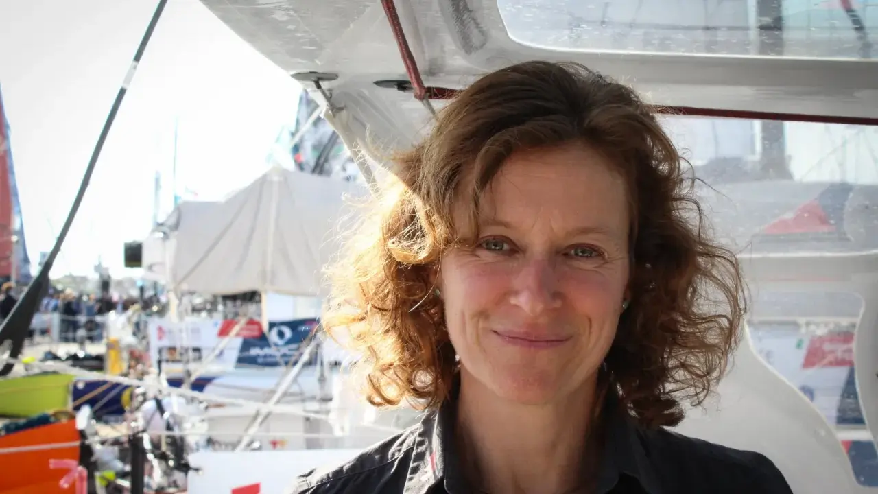 Isabelle Joschke, souriante, sur un bateau, prête pour une nouvelle aventure maritime.