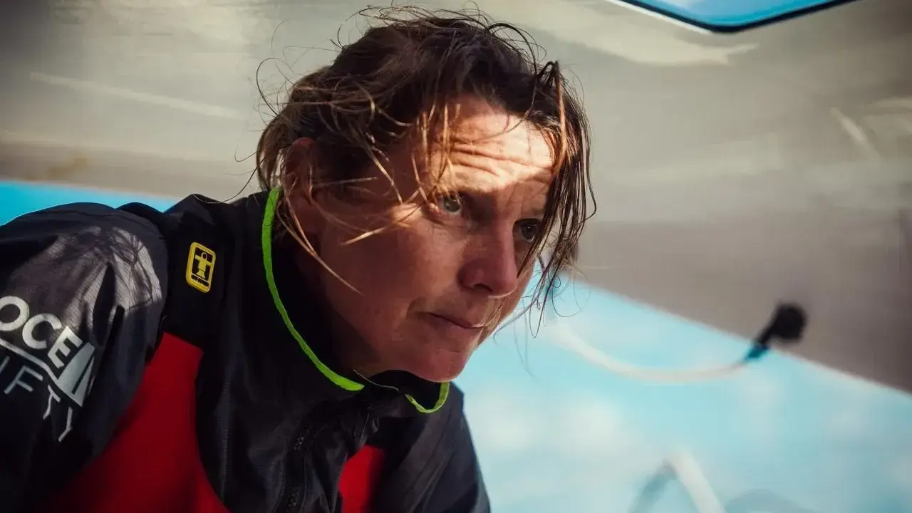 Anne Claire Le Berre, concentrée, le regard intense, le visage marqué par le soleil et le vent, sur un bateau.
