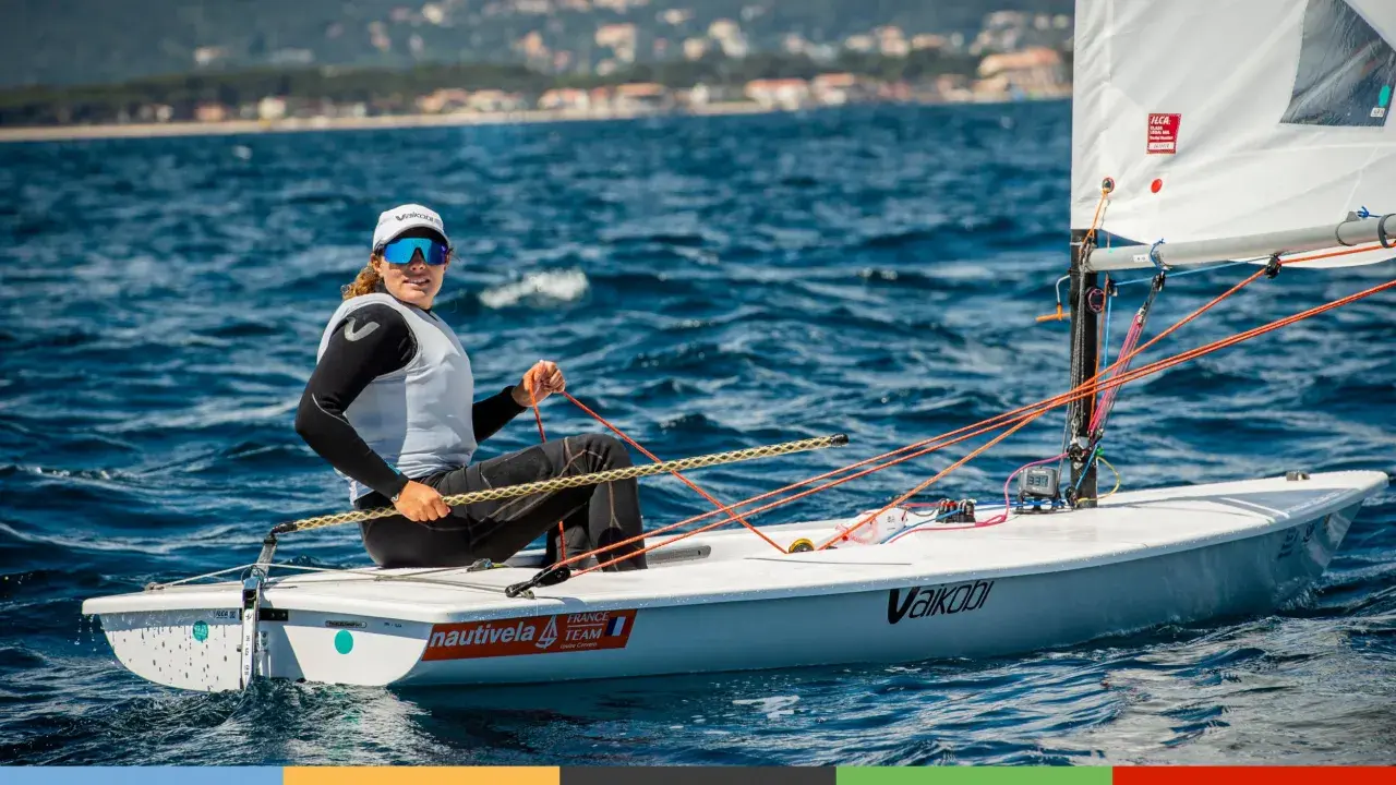 Louise Cervera, navigatrice française, manœuvre son dériveur ILCA sur une mer bleue. Elle porte une casquette et des lunettes de soleil.