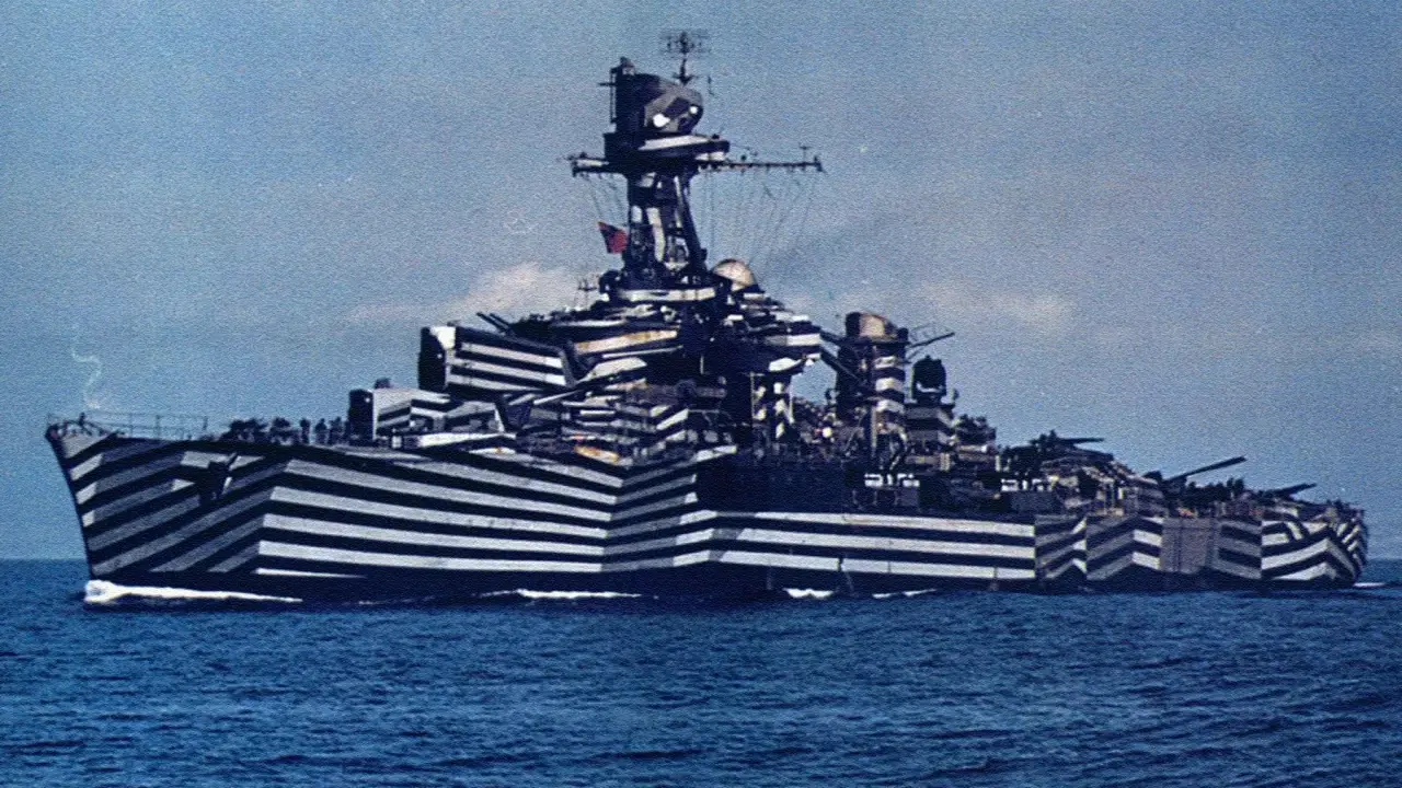 Un navire de guerre à l'impressionnant camouflage zébré, conçu pour tromper l'ennemi. Ce bateau militaire arbore un motif audacieux.