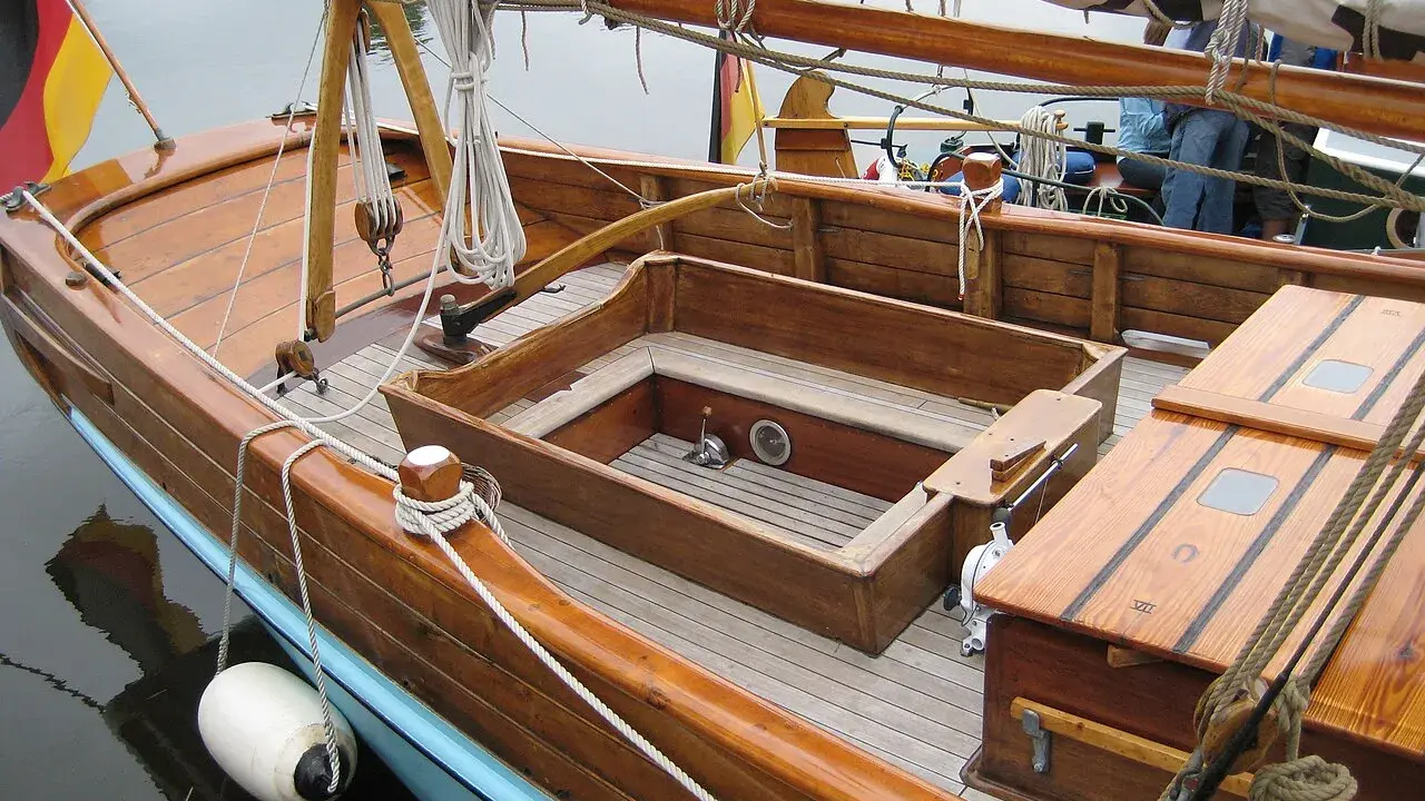 Le cockpit bateau en bois verni, avec ses cordages et sa bouée blanche, prêt pour une nouvelle aventure.