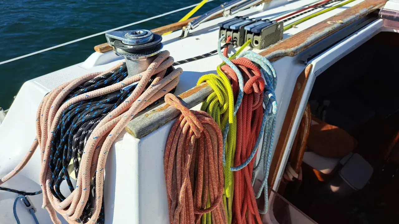 Sur un voilier, la différence entre drisse et écoute est claire : les drisses hissent les voiles, les écoutes les règlent. Ici, des cordages colorés attendent leur usage.