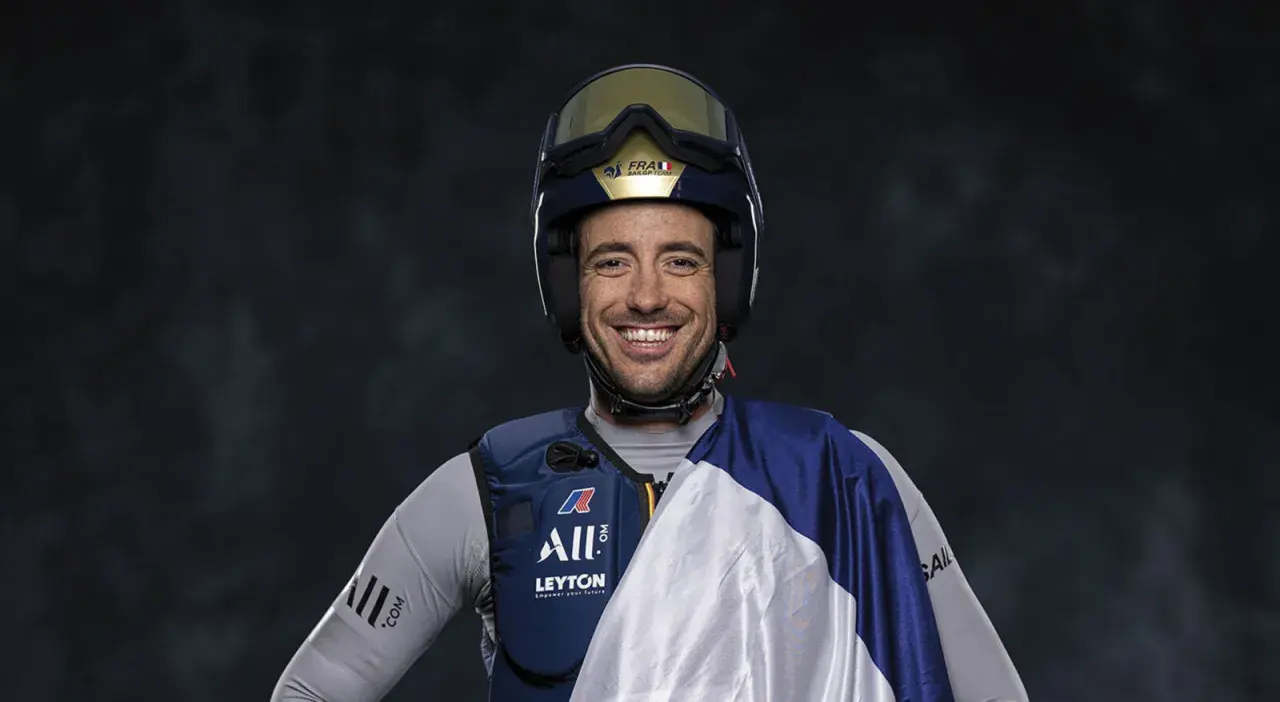 Quentin Delapierre, souriant, porte un casque de voile et une tenue de sport.