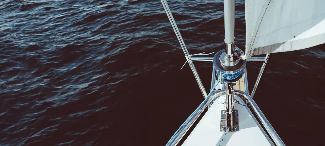 Le voile avant du bateau est prêt à être déployé sur l'eau sombre.