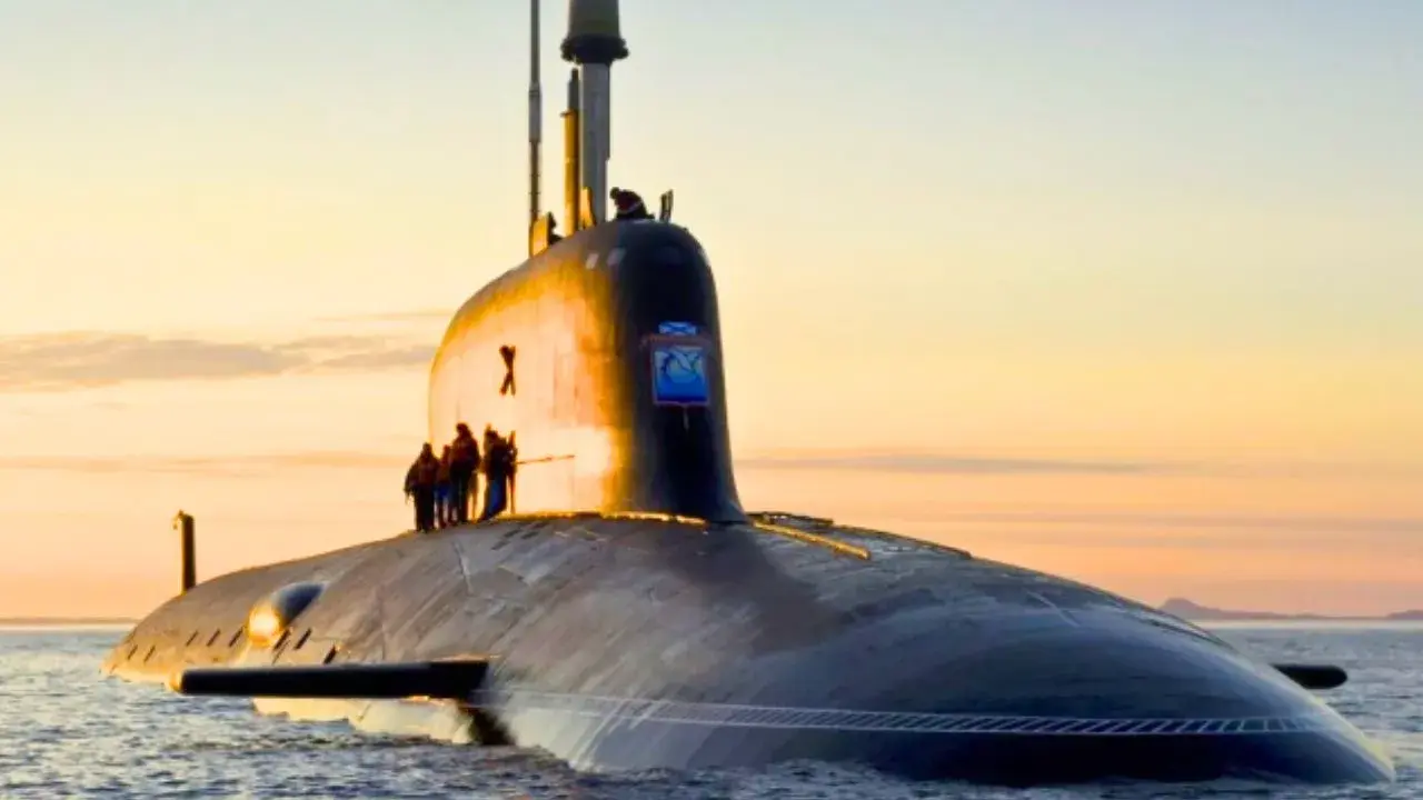Un imposant sous-marin, potentiellement le sous-marin le plus puissant du monde, navigue sur une mer calme au coucher du soleil.
