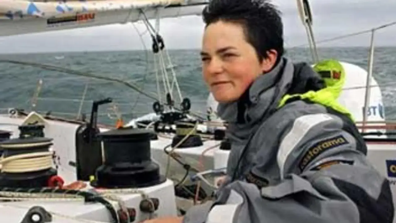 La navigatrice Ellen MacArthur, compagnon de bord sur un voilier, ajuste une voile.