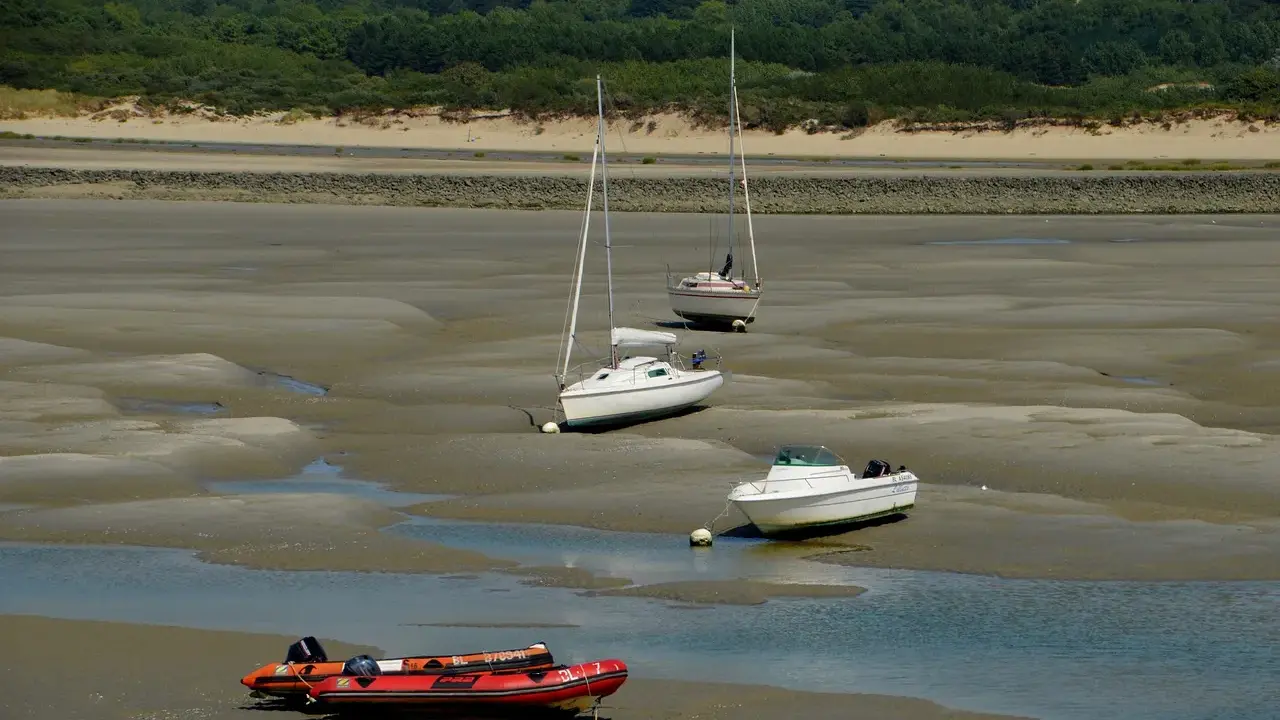 Trois voiliers et un bateau à moteur échoués sur la vase, avec un zodiac rouge au premier plan. Le **kelt 9** est l'un des voiliers.