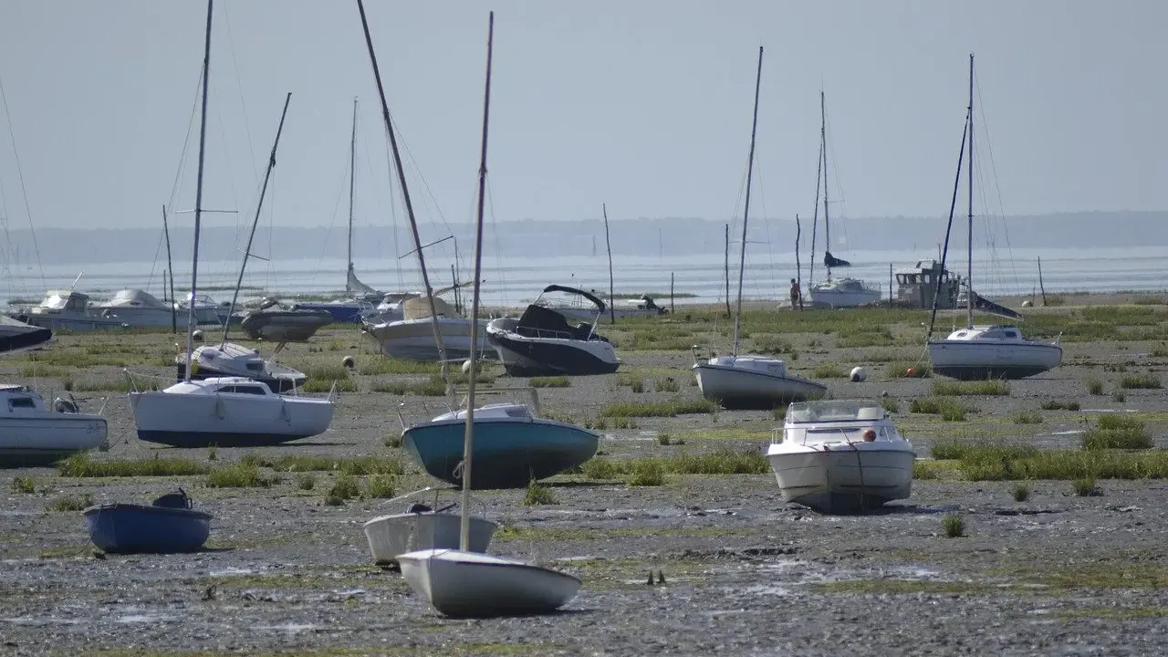 Échoués sur la vase, plusieurs voiliers et bateaux à moteur attendent la marée. Une scène typique de la fiche technique d'un port, avec des bateaux de type Edel 4.