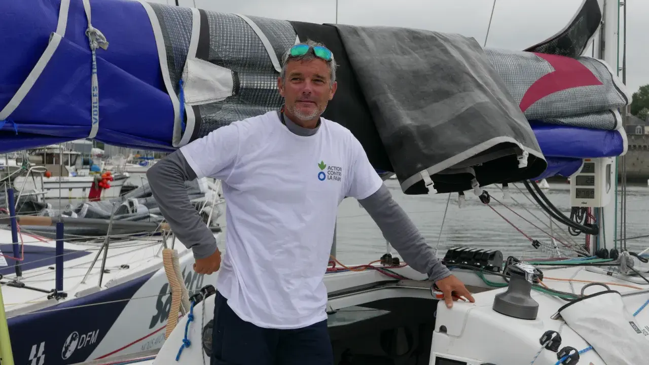 Gildas Mahé, skipper, pose sur son voilier, prêt pour une nouvelle aventure maritime.