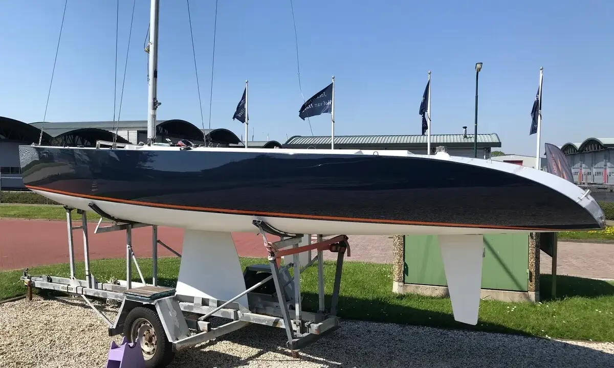 Voilier de course noir et blanc, un modèleBepox 750, sur sa remorque, prêt pour l'aventure.