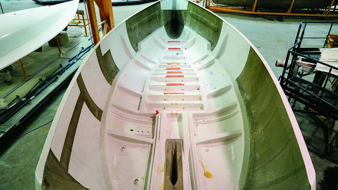 Intérieur d'une coque de bateau en construction, prêt pour le talonnage bateau. Lignes épurées et structure visible.