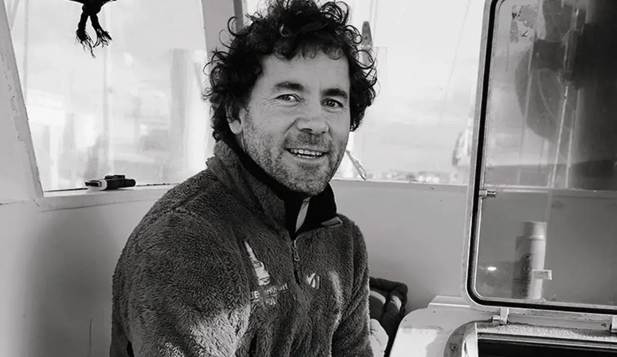 Sébastien Roubinet, un aventurier souriant, pose à l'intérieur d'un bateau, prêt pour sa prochaine expédition.