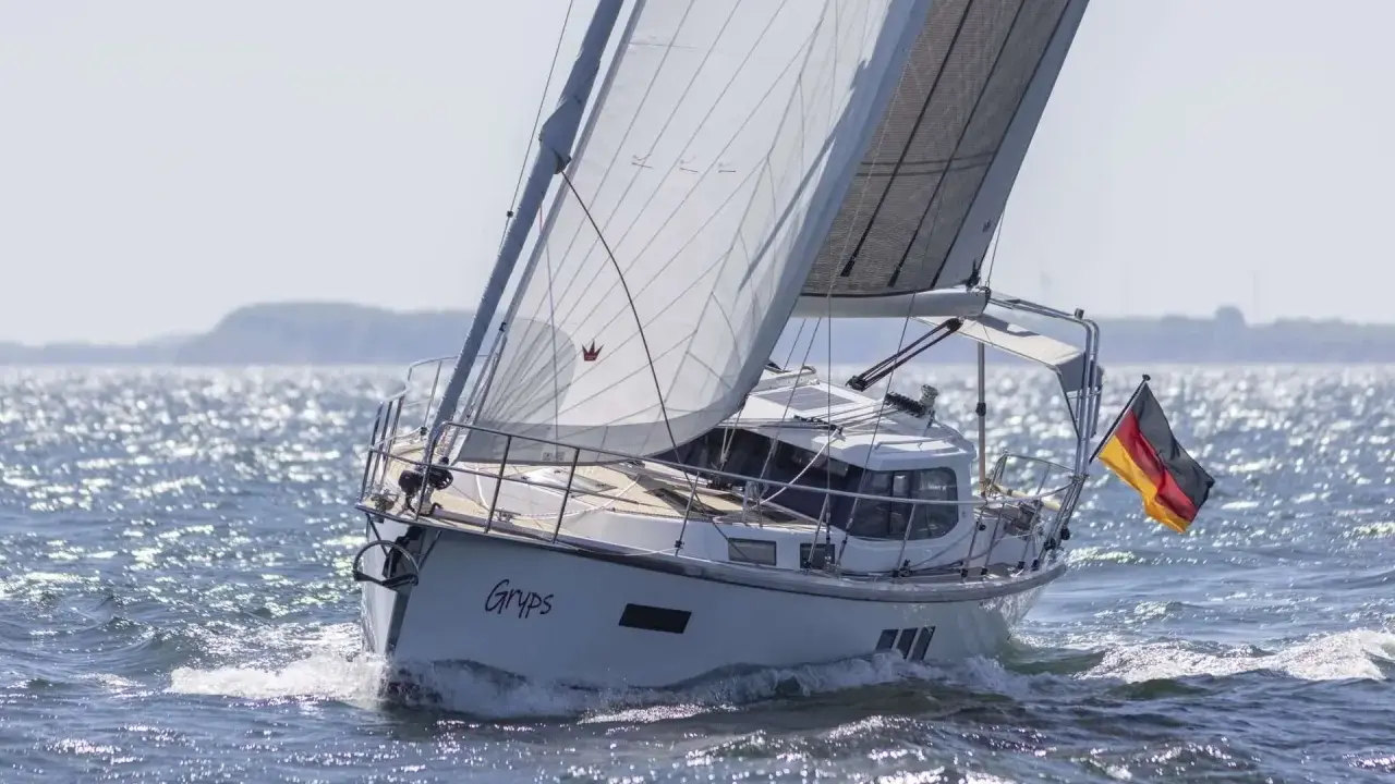 Le voilier Sirius 40 DS "Gryps" navigue sur une mer scintillante, pavillon allemand au vent.