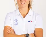 Manon Audinet, athlète française, porte un polo blanc avec les anneaux olympiques et le coq gaulois.
