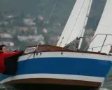 Couple en action sur un voilier transportable hauturier, profitant d'une navigation par temps frais.