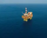 Plateforme pétrolière jackup isolée sur une mer bleue calme.