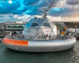 Le bateau Tara Polar Station, une station polaire futuriste, est amarré dans un port sous un ciel dramatique.