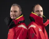 Morgan Lagravière et son coéquipier, deux marins en veste rouge, prêts pour l'aventure en mer.