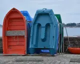 Plusieurs petites barques colorées sont rangées sur le quai, prêtes à être utilisées pour rejoindre son bateau.