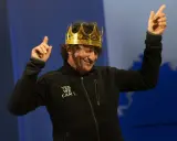 Jean Le Cam, le roi des mers, porte une couronne dorée et une veste noire avec l'inscription "YES WE CAM L".
