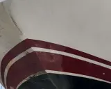 Nettoyage coque bateau acide chlorhydrique : la partie immergée du bateau, avec des traces de salissures et de la peinture rouge et blanche.