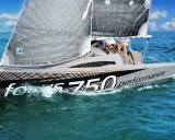 Voile du **Bepox 700** performance fendant les vagues bleues, deux navigateurs à bord.