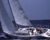 Un voilier navigue sur une mer agitée, ses voiles gonflées par le vent. Un rêve au soleil, 28 avis sur cette belle journée.