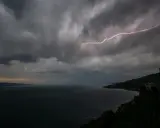 Éclair zébrant le ciel sombre au-dessus du lac Léman, annonçant une violente tempête.