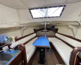 Intérieur d'un voilier, avec banquettes, table bleue et évier. Un coin de fantasia voilier interieur prêt pour l'aventure.