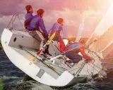 Équipe en pleine action pour apprendre la voile. Le voilier est incliné, les marins ajustent les voiles sous un ciel orageux.