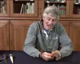 Un homme montre comment faire un nœud de capucin sur manille, un nœud marin essentiel.