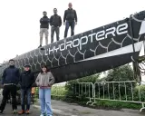 L'équipe pose fièrement devant l'hydroptère 2.0, un navire futuriste prêt à fendre les flots.
