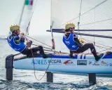 Deux jeunes navigateurs, dont Lou Berthomieu, en action sur un catamaran de sport, le vent gonflant les voiles.