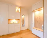 Ambiance chaleureuse dans cet intérieur de Kelt 550, avec des rangements blancs laqués et des niches en bois illuminées. Un miroir ovale ajoute une touche d'élégance.