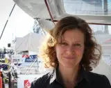 Isabelle Joschke, souriante, sur un bateau, prête pour une nouvelle aventure maritime.