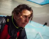 Anne Claire Le Berre, concentrée, le regard intense, le visage marqué par le soleil et le vent, sur un bateau.