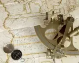Un sextant et une boussole sur une carte ancienne, évoquant la navigation et l'exploration.
