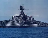 Un navire de guerre à l'impressionnant camouflage zébré, conçu pour tromper l'ennemi. Ce bateau militaire arbore un motif audacieux.