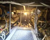 Vue de la salle des machines d'un bateau, avec deux moteurs inboard jaunes. L'entretien régulier est essentiel pour la durée de vie d'un moteur inboard.