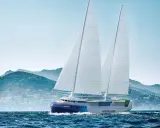 Un porte-conteneurs à voile futuriste navigue sur une mer agitée, avec des montagnes verdoyantes en arrière-plan.