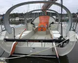 Le voilier "L'Abri Cotier" SB, un modèle kaidoz 31, est amarré dans un port. Son design moderne avec une arche distinctive est visible.