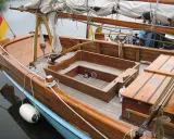 Le cockpit bateau en bois verni, avec ses cordages et sa bouée blanche, prêt pour une nouvelle aventure.