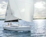 Voilier Dehler 34 naviguant par temps calme. Les voiles blanches sont gonflées, deux personnes sont à la barre. Fiche technique du bateau.