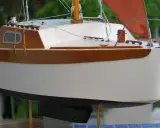 Modèle de voilier corsaire, coque blanche et bois verni, voile orange. Fiche technique détaillée.
